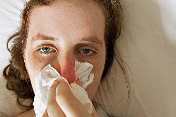Flue Close up of a girl lying in the bed,, smothered with the flu clowns nose stock pictures, royalty-free photos & images