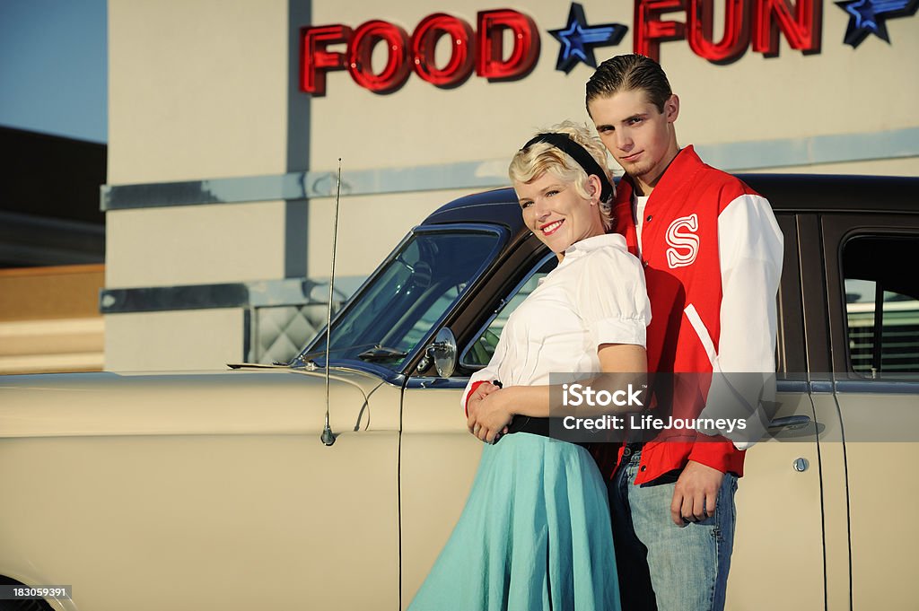 Retrô anos 50 Casal em pé perto de carro antigo e jantar - Foto de stock de 1950-1959 royalty-free