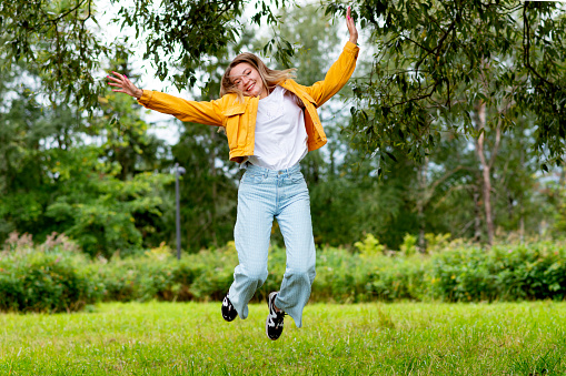 outdoor portrait of a young girl jumping in the park