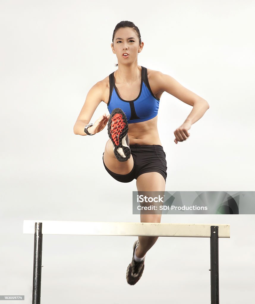 Giovane donna atleta Salto ostacoli - Foto stock royalty-free di Ostacolo