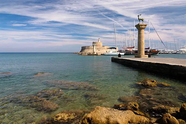 "Rhodes island landmark, Port entry, Mandraki. The medieval lighthouse, and the two deers believed to be the base of Colossus, one of the 7 wonders of the ancient world. Recently re-constructed.The historical port is still used today as a marina by small yachts and ferries.Nikon D2X, Polariser filter used.Similar photos:"