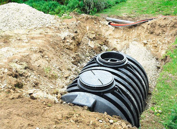 A black septic tank halfway buried in dirt outside Installation of a drainage tank (septic tank) in a domestic garden sewage photos stock pictures, royalty-free photos & images