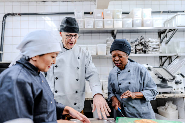 istock Chef talking with employees in a commercial kitchen 1830607595