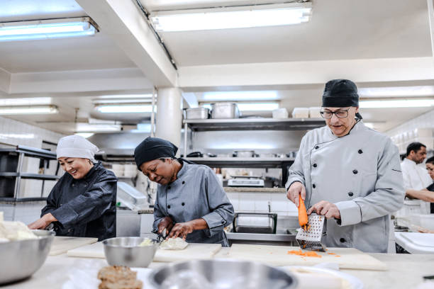 istock Coworkers talking and chopping vegetables in a commercial kitchen 1830609356