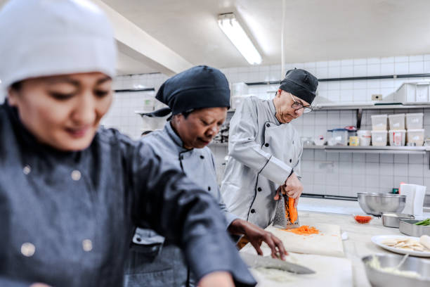istock Coworkers chopping vegetables in a commercial kitchen 1830609391