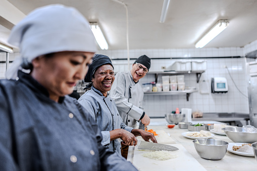 Portrait of coworkers chopping vegetables in a commercial kitchen