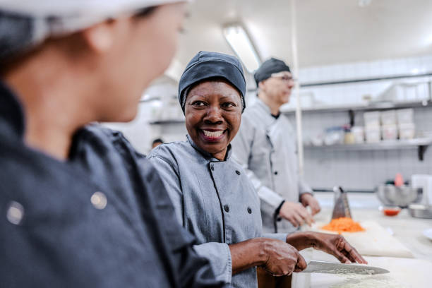 istock Coworkers talking and chopping vegetables in a commercial kitchen 1830609946
