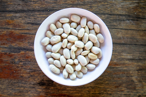 Organic White Beans protein plants that are beneficial to the body and health on a white plate.