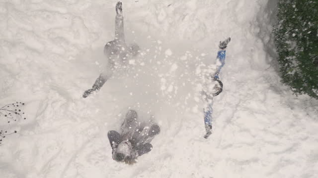 Drone aerial footage of teenage kids are playing in winter backyard