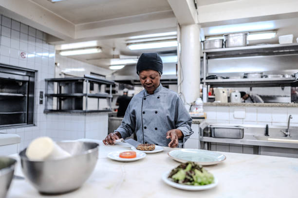 Senior woman preparing a food plate in a commercial kitchen