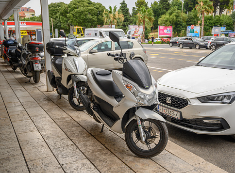 Split, Croatia - July 25, 2023: Motorcycles in a street car park in Split, Croatia.