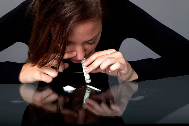 Young woman snorting coke