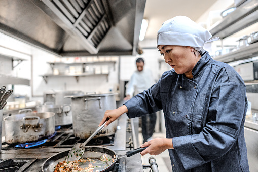 Mature woman cooking in a commercial kitchen