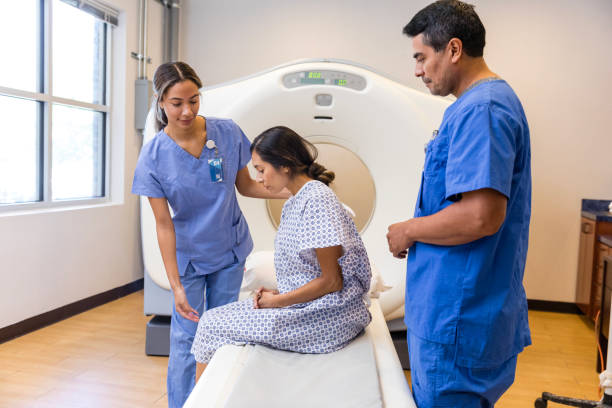 istock Two CT technicians assist woman before scan 1830615110