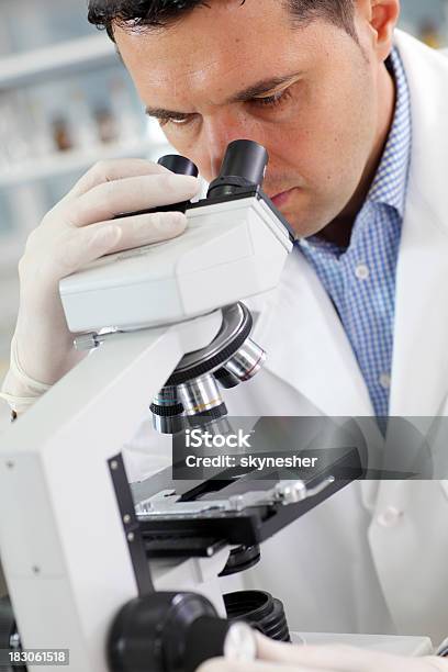 Scienziato Ricercatore Guardando In Un Microscopio In Laboratorio - Fotografie stock e altre immagini di Adulto