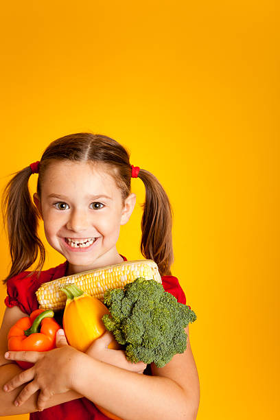 istock Happy Girl Holding Vegetables, Orange Bell Pepper, Broccoli, Squash, Corn 183061546