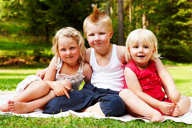 istock little boy hugging his sisters in garden 183061564