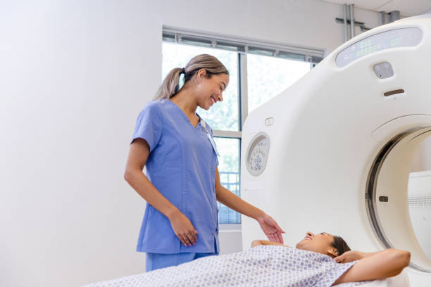 istock Female CT tech and female patient smile together before scan 1830615677