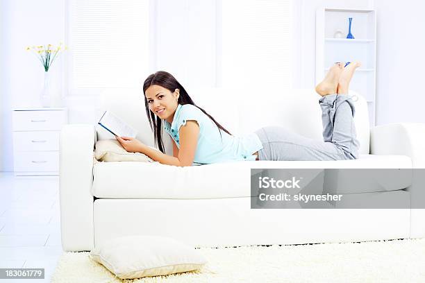 横になって読書と美しい女性の自宅でご予約 - 1人のストックフォトや画像を多数ご用意 - 1人, まぶしい, カメラ目線