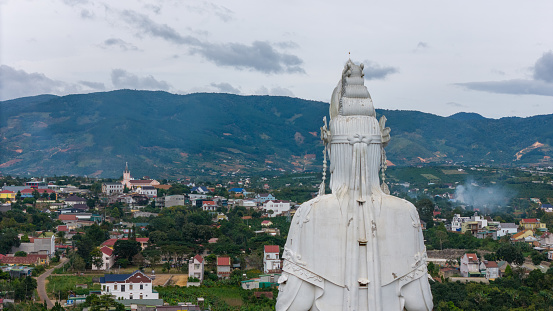 Aerial view of Linh An Pagoda, DaLat city, Lam Dong province, Vietnam. A statue is white and 71 meters high, near Thac Voi - Elephant waterfall, forest and city scene in background.