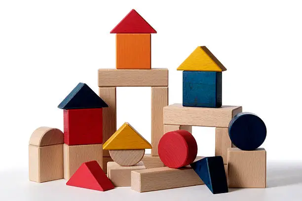 A partially constructed home, built from colorful wood blocks building isolated on white background.