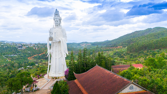 Aerial view of Linh An Pagoda, DaLat city, Lam Dong province, Vietnam. A statue is white and 71 meters high, near Thac Voi - Elephant waterfall, forest and city scene in background.