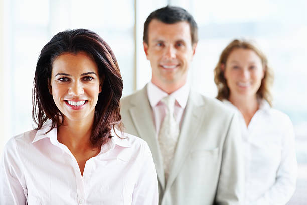 istock Middle aged business female with blurred colleagues in background 183062336