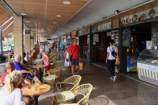Morro Jable, Fuerteventura, Spain, November 21, 2023 - Souvenir stores and covered sidewalk cafes at the Centro Comercial Palm Garden on Av. Tomás Grau Gurrea in Morro Jable, Spain.