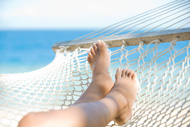 istock Womans feet in a hammock on tropical beach 183062622