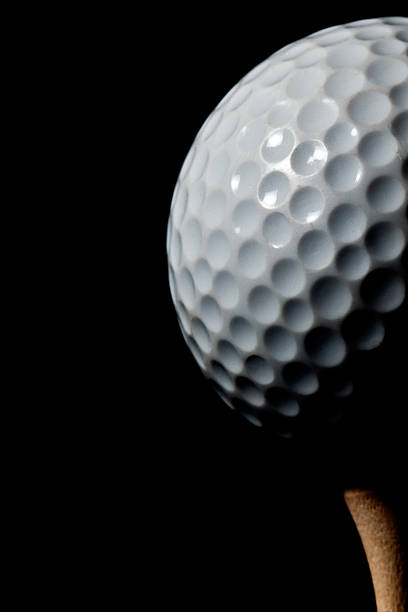 istock A used golf ball on a tee with a black background. 183063139