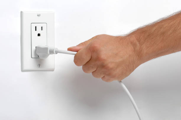 человек потянув электрический разъем настенной розетке на whte от - electric plug outlet pulling electricity стоковые фото и изображения