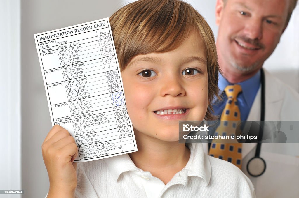 Young Boy de retención de inmunización registro en consultorio médico - Foto de stock de 4-5 años libre de derechos