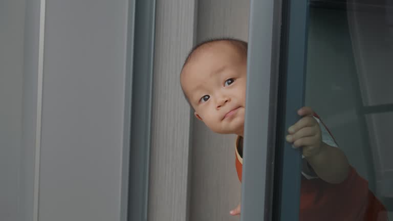 City Joy: Adorable Toddler Curiosity on a Sunny Day in Apartment Living.