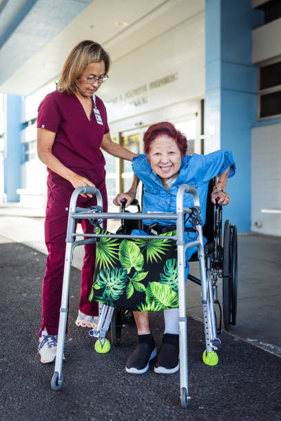 istock Occupational therapist helping elderly patient transition from wheelchair to using a mobility walker 1830638874