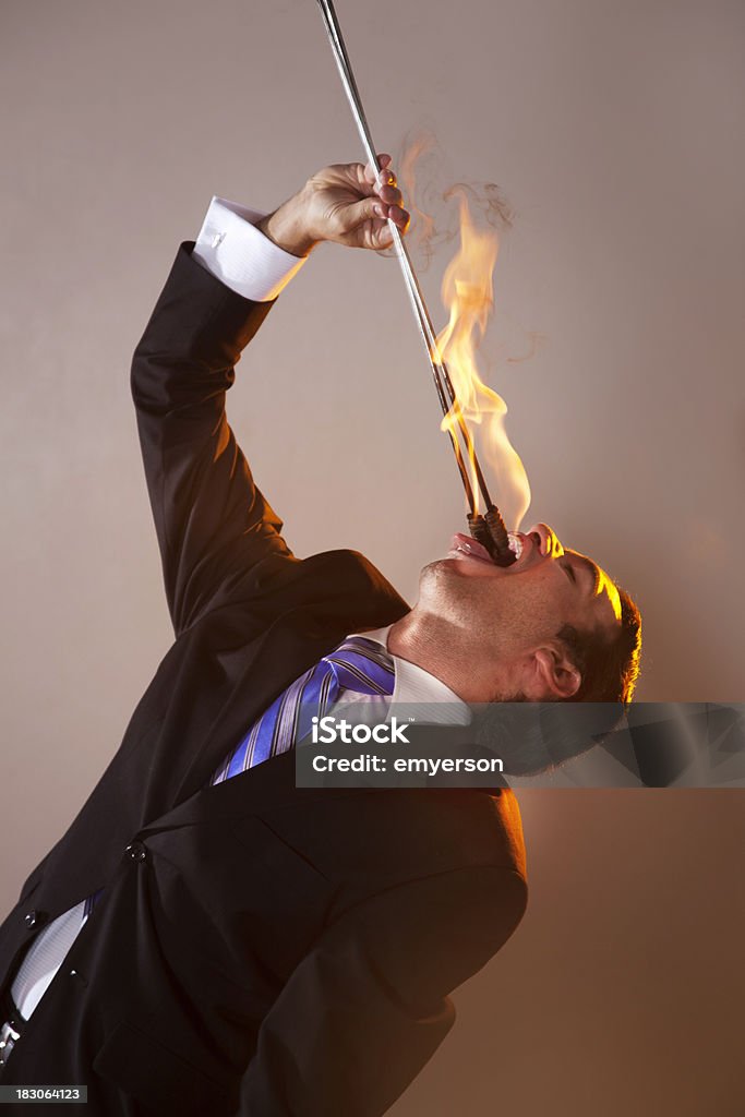 Fire Eating Businessman You think your job is tough A businessman eating fire. Adult Stock Photo