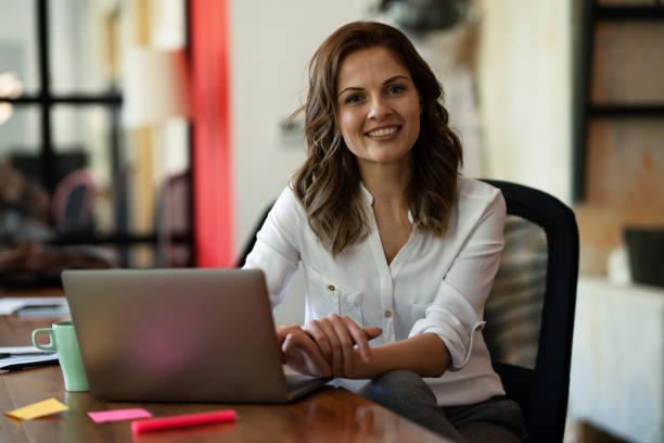 istock Beautiful woman drinking coffee while working on laptop. 1830643733