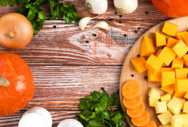 istock Vegetables for making pumpkin soup on on a wooden kitchen table. Top view. Place for text. 1830648598