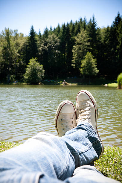 istock Legs of a man relaxing on the shore  lake 183065084