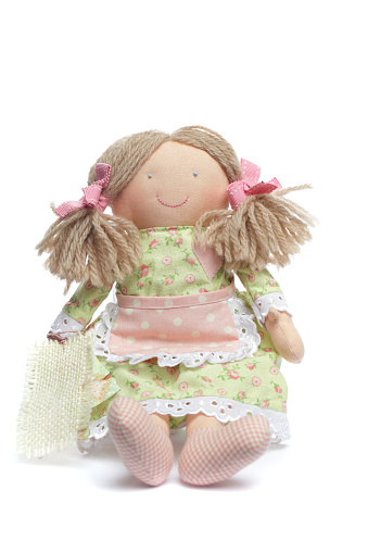 Traditional handmade doll in dress maded pink and green color natural cotton linen material. Baby toy or interior decoration on white background