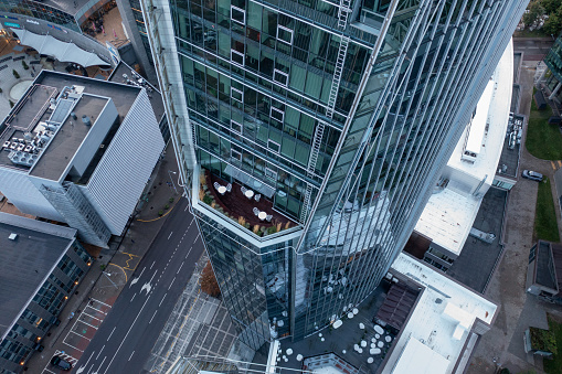 Drone photography of skyscraper balcony with tables and chairs for people during autumn cloudy day