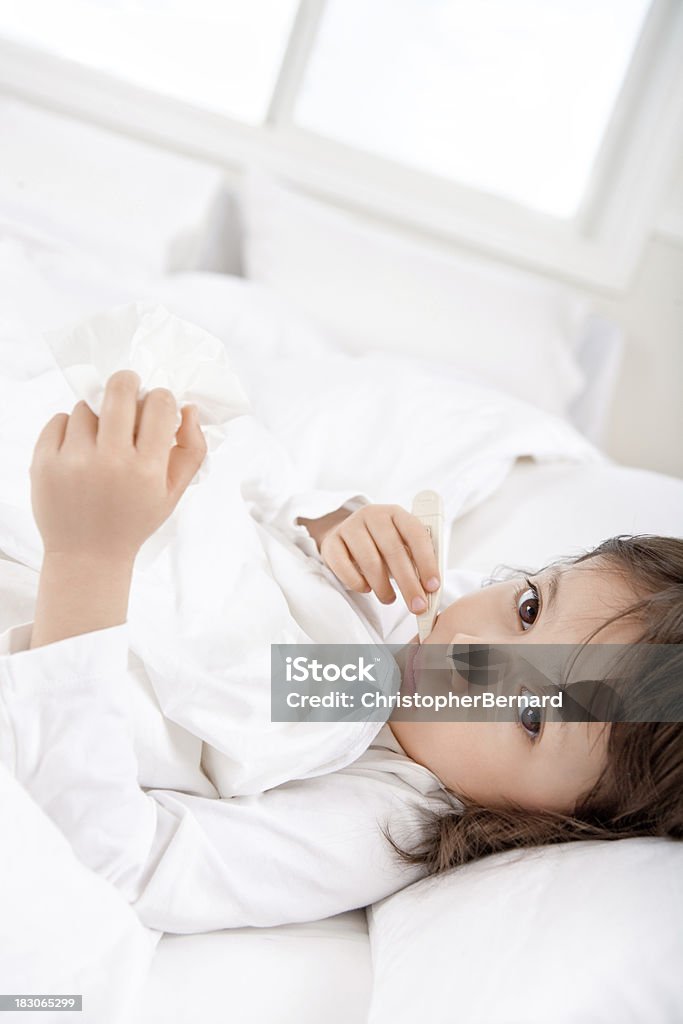 Sick niña con un termómetro en la cama - Foto de stock de 4-5 años libre de derechos