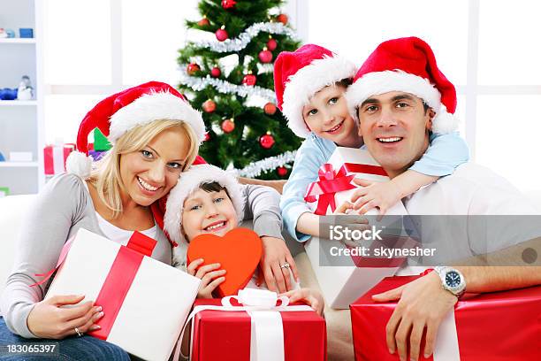 Glückliche Familie Holding Christmas Gift Stockfoto und mehr Bilder von Attraktive Frau - Attraktive Frau, Baum, Beide Elternteile