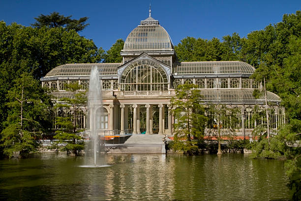 Crystal Palace Retiro Public Park Madrid This is a shot from across the lake of the Crystal Palace at the public park Retiro in the center of Madrid.   This is a public park with dozens of buildings and museums. arboretum stock pictures, royalty-free photos & images