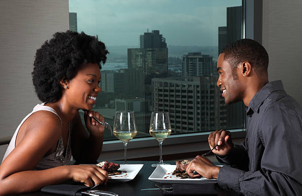 This is a photo of a young African American couple having a romantic dinner together. There are similar images of this couple in the lightbox below.