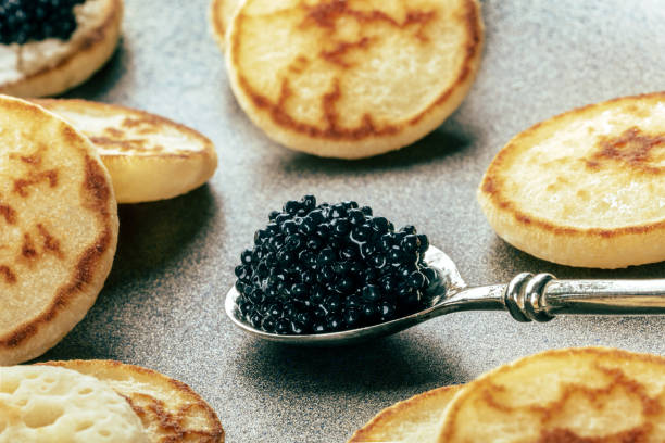 istock Silver spoon with caviar close-up with mini pancakes, an elegant appetizer 1830665423