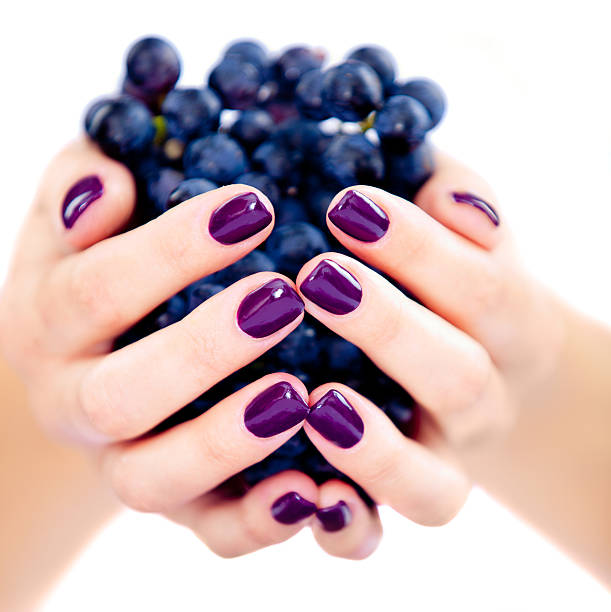 Beautiful woman's hand detail holding red grapes.