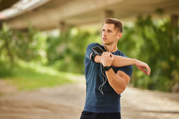 istock Young man stretching arm under bridge before workout outdoors 1830677562