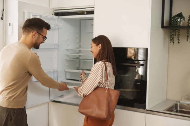 istock Young couple choosing new refrigerator at appliance store 1830679197