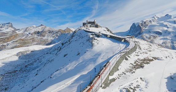 Grossglockner, Austria - July 21, 2013: Parking place on a viewing platform on the Grossglockner High Alpine Road (Salzburg, Austria). Cars parked. People wander around and enjoy the view. A couple on a information table about mountain names.