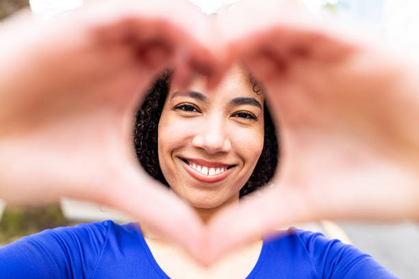 istock Happy young woman gesturing heart shape with hands 1830696455
